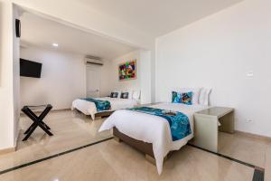 a hotel room with a bed, chair, and a desk at Hotel Regatta Cartagena in Cartagena de Indias