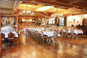 ein Bankettsaal mit weißen Tischen und Stühlen und Kronleuchtern in der Unterkunft Hotel Rhönhof in Oberleichtersbach