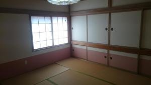 une pièce vide avec une fenêtre et quelques armoires dans l'établissement IZARI Village, à Eniwa