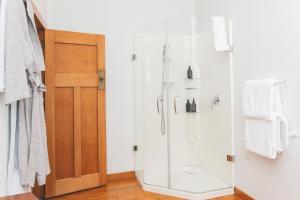 a shower with a glass door in a bathroom at Cedar House in Gisborne