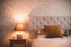 a bedroom with a bed and a lamp on a table at Cedar House in Gisborne