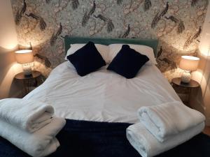 a white bed with two pillows and towels on it at Home from Home Stay Margate in Margate