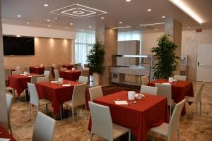 un restaurante con mesas rojas y sillas blancas en Hotel Playa, en Bibione