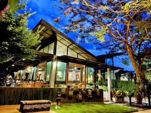 a house with glass windows and a bench in the yard at Family House Zen Boutique Resort in Pai