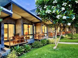 a house with wooden benches on the front of it at Family House Zen Boutique Resort in Pai