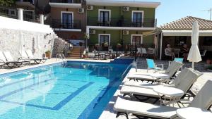 a swimming pool with lounge chairs and a hotel at Fiorella Sea View in Megali Ammos