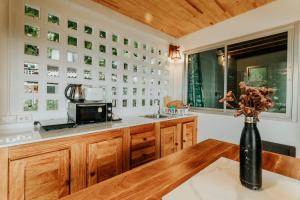 a kitchen with wooden cabinets and a vase with flowers on a table at Cookies Salad Resort in Salad Beach