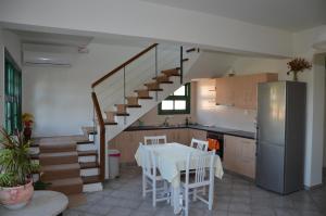 a kitchen with a table and a staircase in a room at Rena's House in Kalogria