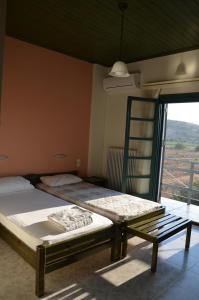 a bedroom with two beds and a window at Rena's House in Kalogria