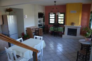a kitchen and living room with a table and a fireplace at Rena's House in Kalogria