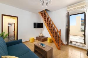 a living room with a blue couch and a staircase at Sea La Vie Villa Symi in Symi