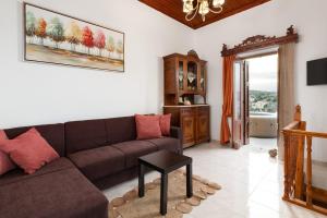 a living room with a couch and a table at Sea La Vie Villa Symi in Symi