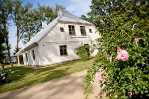 a white house with flowers in front of it at Zyplių Dvaro Oficina Viešbutis 