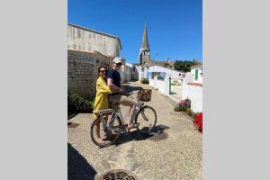 un hombre y una mujer en bicicleta por una calle en Elégante maison d'architecte, Spa à débordement, en La Noue