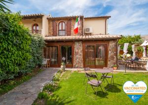 a house with a table and chairs in the yard at B&B La Dolce Vita in Flumini di Quartu