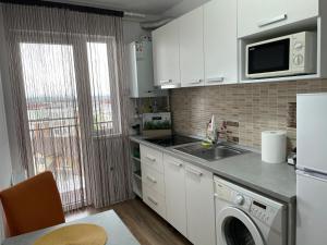 a kitchen with a sink and a microwave at ConfortMax in Baia Mare