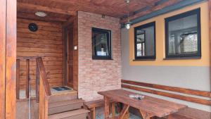 un banco de madera sentado en el porche de una casa en CHATKY JANA en Doksy