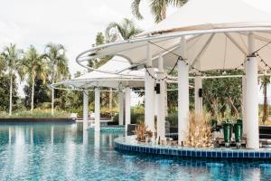a pool at a resort with umbrellas in the water at Rua Rasada Hotel - The Ideal Venue for Meetings & Events in Trang