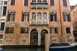 un edificio en el agua con un barco delante en palazzo suite ducale, en Venecia