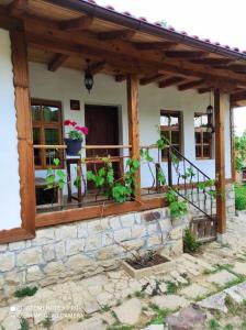 uma casa com uma varanda com flores em Boutique guest house "SamiKan" em Elena