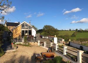 ein weißes Haus mit einem Zaun davor in der Unterkunft Red Kite Cottage in Carmarthen