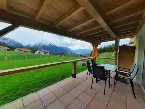 a patio with a table and chairs and a view of mountains at Das Aparthotel Olympia Tirol in Seefeld in Tirol