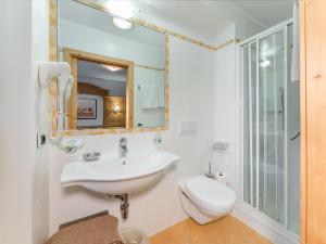 a bathroom with a sink and a toilet and a mirror at B&B MARINA contacless check in in Santa Cristina Gherdëina