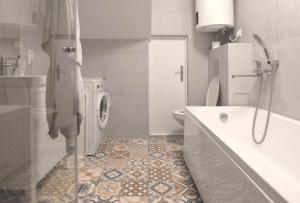 een badkamer met een bad, een toilet en een wastafel bij Apartamentai Juodkrantėje in Juodkrantė