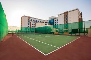 a tennis court with a tennis racquet on it at Hili Rayhaan by Rotana in Al Ain