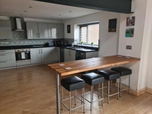 a kitchen with a wooden table and stools at The Studio in Farmborough