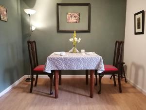 a dining room table with a table cloth and chairs at La Vieille Gorce - Chambres d'Hôtes in the Vienne in Asnois