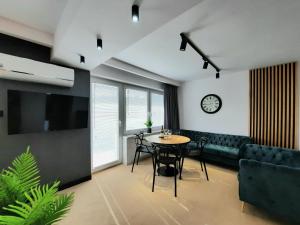 a living room with a table and a couch at GoldenApart Apartamenty 2-sypialniowe - Grzany Basen - Kameralny Klimat in Krynica Morska