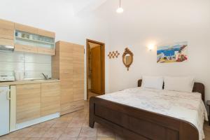 a bedroom with a bed and a kitchen at Lena Studios in Skala Potamias