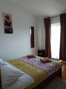 1 dormitorio con 1 cama con 2 toallas en Apartments Monika, en Novi Vinodolski