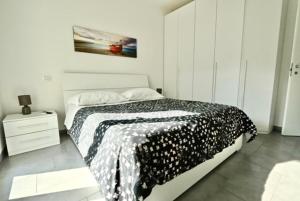 Appartamento ad Alba Adriatica في ألبا أدرياتيكا: غرفة نوم بسرير وبطانية بيضاء وسوداء