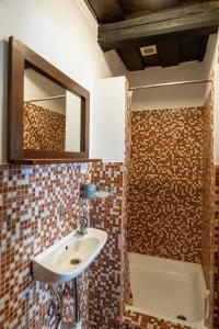 een badkamer met een wastafel, een spiegel en een bad bij Ubytovanie na včelej farme in Polichno