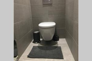 een badkamer met een toilet en een zwart tapijt bij Bel appartement dans le centre ville de Cavalaire in Cavalaire-sur-Mer