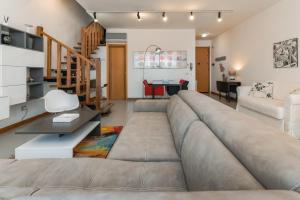 duży salon z dużą kanapą w obiekcie Magnolia - Dario apartment w mieście Fertilia
