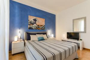 sypialnia z dużym łóżkiem i niebieską ścianą w obiekcie Magnolia - Dario apartment w mieście Fertilia