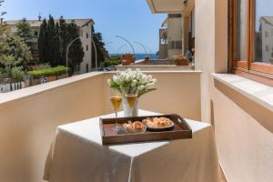 stół z tacą z jedzeniem i napojami na balkonie w obiekcie Magnolia - Dario apartment w mieście Fertilia