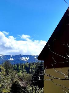 a view of a snowy mountain range from a house at Słoneczny dom in Piechowice