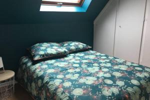 1 Schlafzimmer mit einem Bett mit einer Blumendecke und einem Fenster in der Unterkunft Gîte alsacien in Eckwersheim