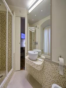 La salle de bains est pourvue d'un lavabo, d'une baignoire et d'un miroir. dans l'établissement Polinari Rooms San Pietro Roma, à Rome