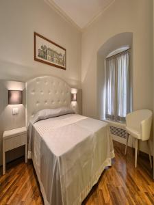 una camera da letto con un grande letto bianco e una finestra di Polinari Rooms San Pietro Roma a Roma