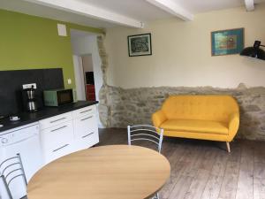 a living room with a yellow couch and a table at La Gente in Pernes-les-Fontaines