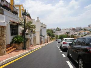 ulica z samochodami zaparkowanymi po stronie drogi w obiekcie Carmen Rooms -- Boutique B&B by the sea w mieście Nerja