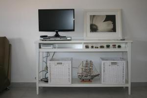 a tv sitting on top of a white shelf with a tv at Fuzeta beach holiday apartment in Fuzeta