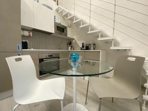 a glass table in a kitchen with white chairs at La Volta in Como