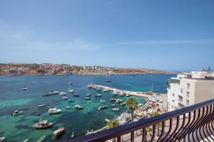 a view of a harbor with boats in the water at Harbour Lights Seafront Penthouse, with large terrace with stunning panoramic sea views - by Getawaysmalta in St Paul's Bay