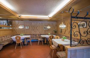 restauracja ze stołami i krzesłami w pokoju w obiekcie Hotel Alpenrast w mieście Riva di Tures